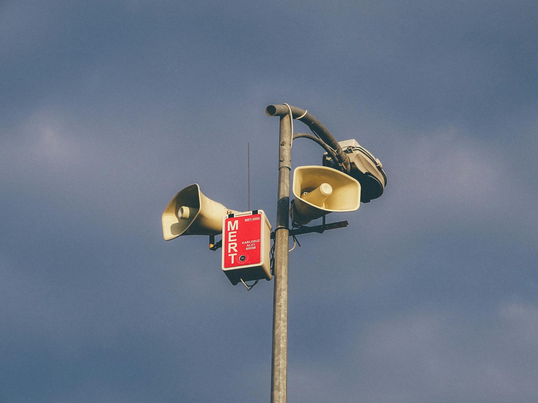 Alarm siren tower with speakers mounted on wall